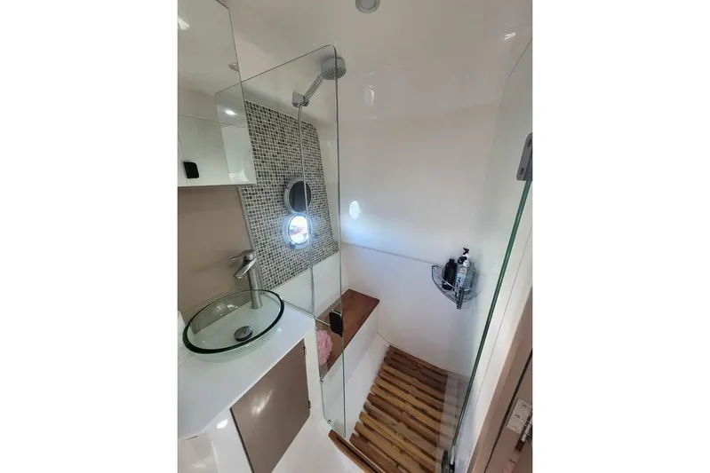  Yacht Photos Pics Modern bathroom in 2024 Hanover 387 with glass sink, shower, and wooden accents.