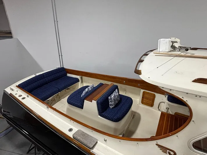 Celebration Yacht Photos Pics 2002 Hinckley Picnic Boat 36 with blue seating and wooden accents in a showroom.