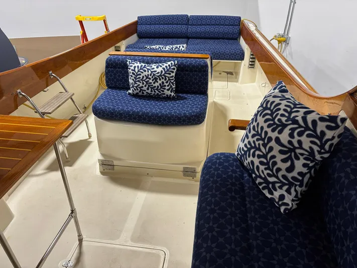 Celebration Yacht Photos Pics 2002 Hinckley Picnic Boat 36 interior with blue patterned cushions and wooden accents.