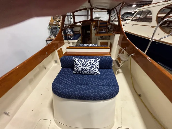Celebration Yacht Photos Pics 2002 Hinckley Picnic Boat 36 interior with blue cushioned seating and wooden accents.