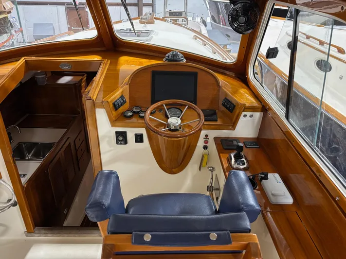 Celebration Yacht Photos Pics Helm of 2002 Hinckley Picnic Boat 36 with wooden accents and modern navigation equipment.