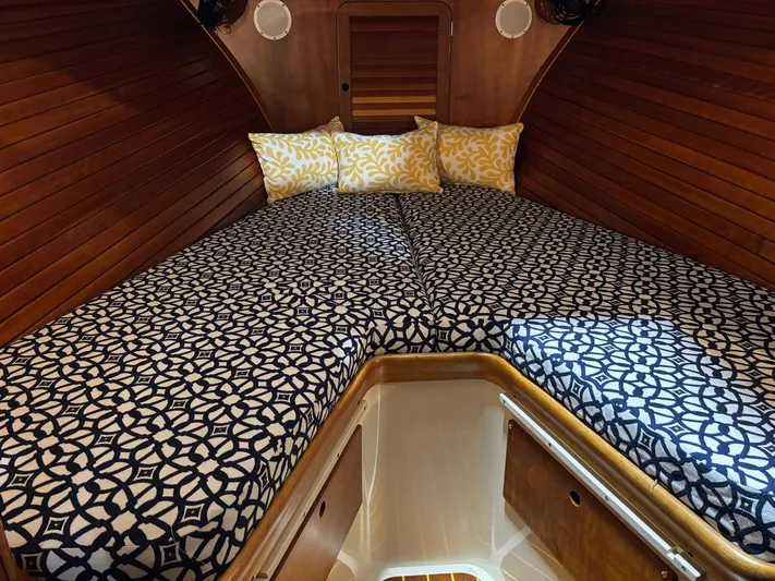 Celebration Yacht Photos Pics Cozy cabin interior of 2002 Hinckley Picnic Boat 36 with patterned bedding and wooden walls.