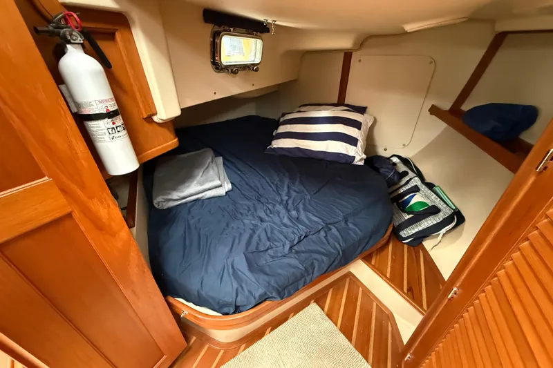 Pelican Yacht Photos Pics Cozy cabin interior of 2008 Island Packet 370 sailboat with bed and fire extinguisher.