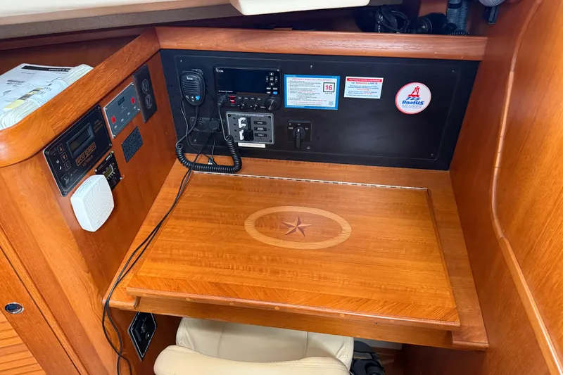 Pelican Yacht Photos Pics Navigation station of 2008 Island Packet 370 sailboat with communication equipment and wooden desk.