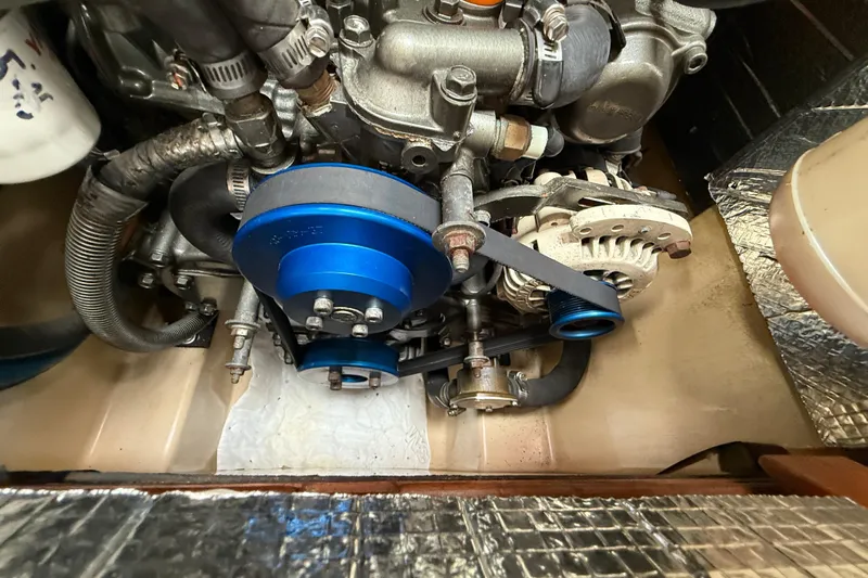 Pelican Yacht Photos Pics Engine compartment of a 2008 Island Packet 370 sailboat, featuring blue pulleys and belts.
