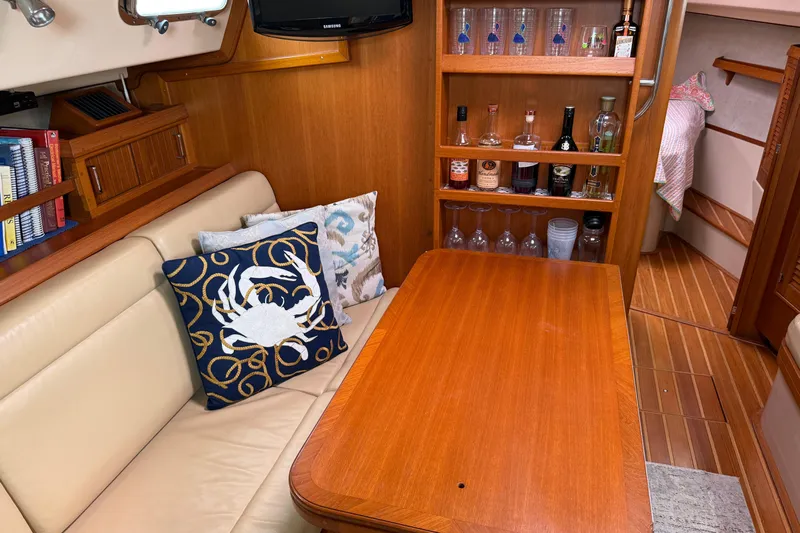 Pelican Yacht Photos Pics Cozy 2008 Island Packet 370 yacht interior with wooden table, cushions, and bar area.