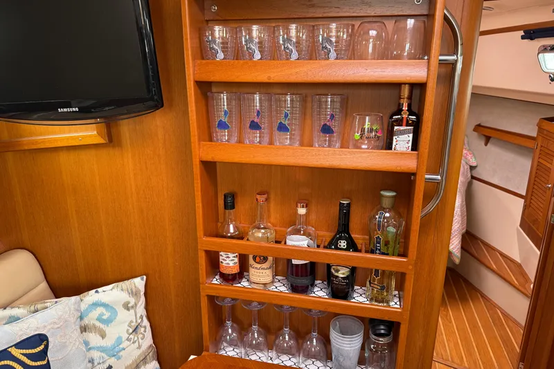 Pelican Yacht Photos Pics Bar area inside 2008 Island Packet 370 yacht with glasses and assorted liquor bottles.
