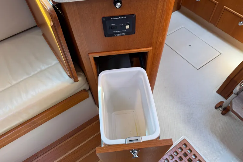 Pelican Yacht Photos Pics Interior of 2008 Island Packet 370 yacht with open cabinet and trash bin.
