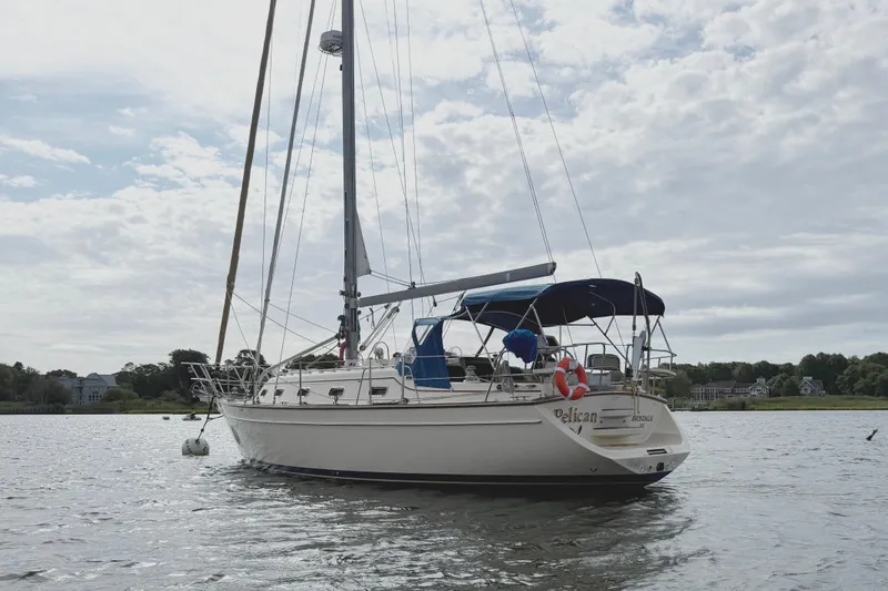 Pelican Yacht Photos Pics 2008 Island Packet 370 sailboat anchored on calm water under a cloudy sky.
