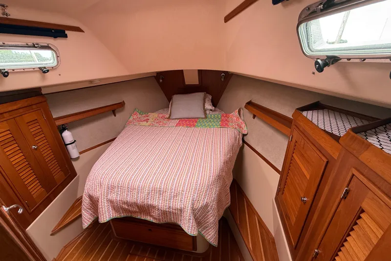 Pelican Yacht Photos Pics Cozy cabin interior of 2008 Island Packet 370 sailboat with bed and wooden storage.