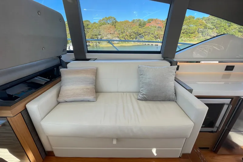 Bar Dog Yacht Photos Pics Luxurious interior of 2020 Tiara 53C yacht with white sofa and scenic window view.