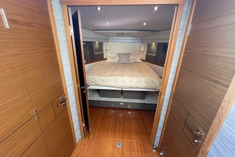 Bar Dog Yacht Photos Pics Luxurious bedroom interior of 2020 Tiara 53C yacht with wooden finishes and cozy bedding.