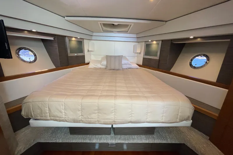 Bar Dog Yacht Photos Pics Luxurious bedroom interior of 2020 Tiara 53C yacht with elegant bedding and porthole windows.