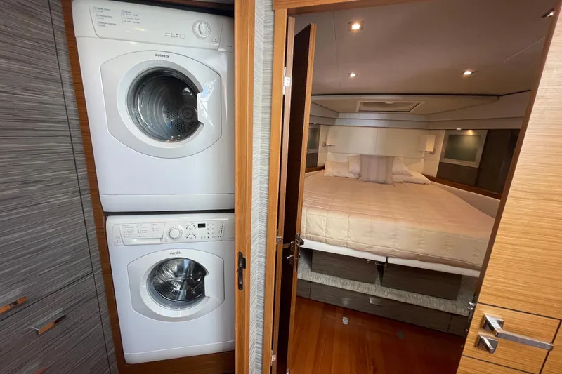 Bar Dog Yacht Photos Pics Stacked washer and dryer beside a cozy bedroom in a 2020 Tiara 53C yacht.