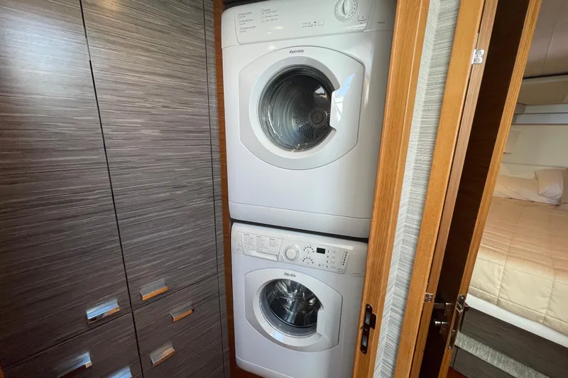 Bar Dog Yacht Photos Pics Stacked washer and dryer in Tiara 53C yacht, 2020 model, with wood paneling.