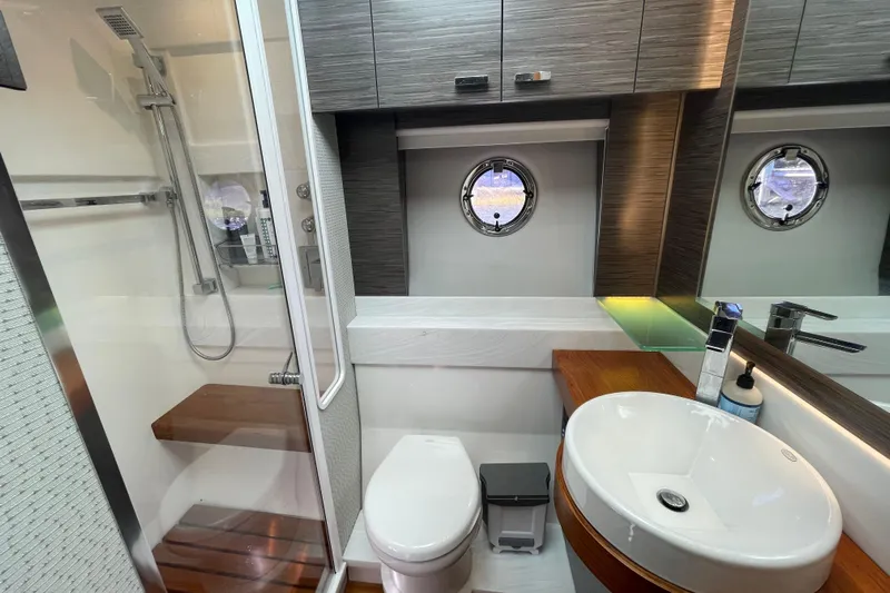 Bar Dog Yacht Photos Pics Luxurious Tiara 53C 2020 yacht bathroom with modern fixtures and porthole window.