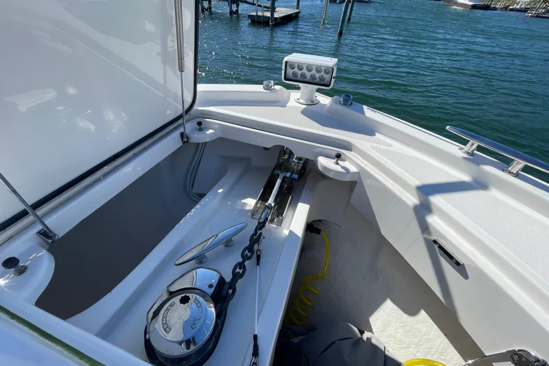 Bar Dog Yacht Photos Pics 2020 Tiara 53C boat anchor compartment with chain and winch, docked on calm water.