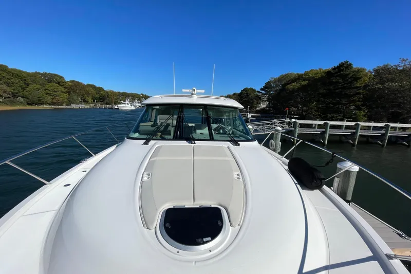 Bar Dog Yacht Photos Pics 2020 Tiara 53C yacht docked by a scenic waterfront with clear blue skies.