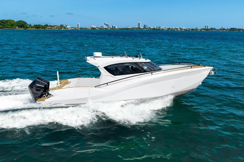  Yacht Photos Pics 2025 Novielli SERE boat cruising on blue ocean with city skyline in background.