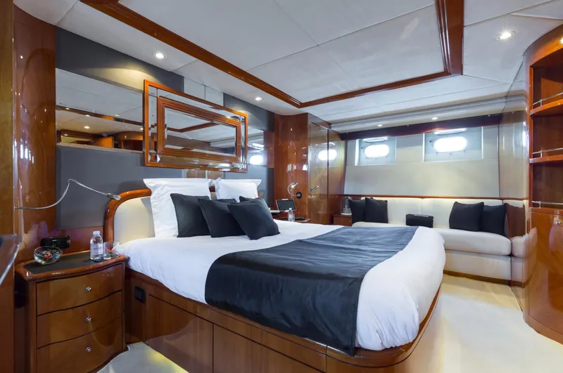 Yacht Photos Pics Luxurious bedroom interior of 1999 Azimut 100 Jumbo yacht with elegant wood finishes.