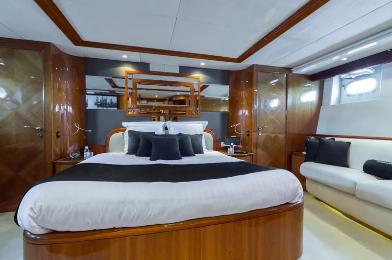  Yacht Photos Pics Luxurious bedroom interior on a 1999 Azimut 100 Jumbo yacht with elegant wood finishes.