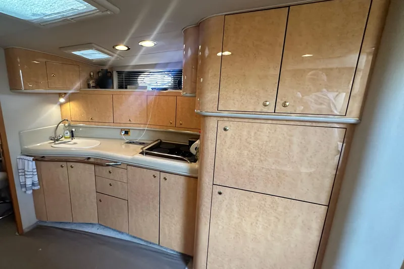 Bad Habit Yacht Photos Pics Luxurious 1998 Sea Ray 450 Sundancer yacht kitchen with wood cabinetry and modern amenities.