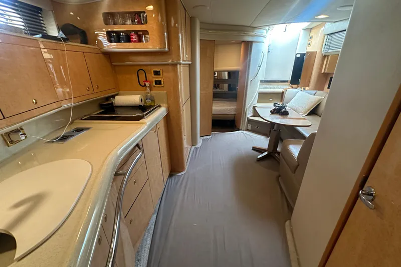 Bad Habit Yacht Photos Pics Interior of 1998 Sea Ray 450 Sundancer yacht, featuring kitchen and seating area.