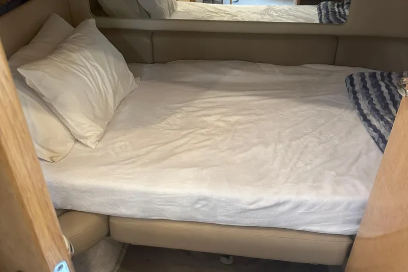 Bad Habit Yacht Photos Pics 1998 Sea Ray 450 Sundancer cabin with a neatly made bed and pillows.