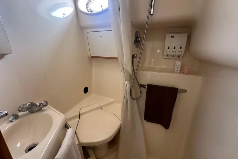 Bad Habit Yacht Photos Pics Bathroom interior of 1998 Sea Ray 450 Sundancer yacht, featuring sink and shower.