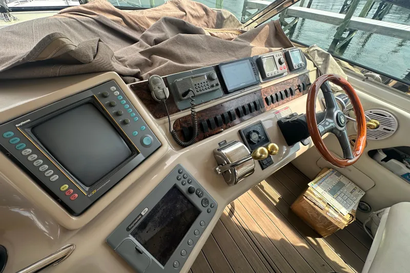 Bad Habit Yacht Photos Pics 1998 Sea Ray 450 Sundancer helm with navigation equipment and wooden steering wheel.