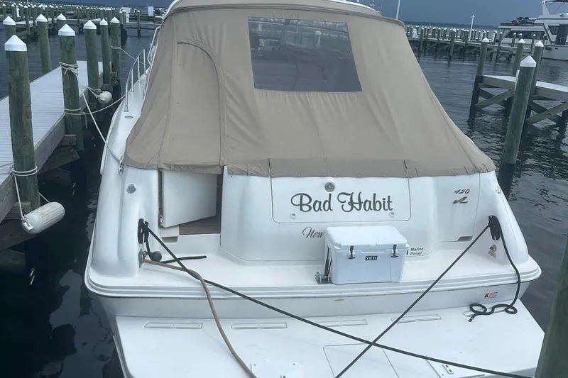 Bad Habit Yacht Photos Pics 1998 Sea Ray 450 Sundancer docked, rear view with tan cover and cooler.