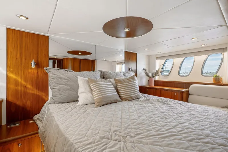 Yacht Photos Pics Luxurious bedroom interior of 2008 Sunseeker Predator 62 yacht with elegant wood finishes.