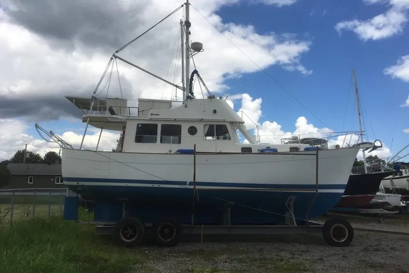  Yacht Photos Pics 1997 Willard Marine 40 Pilothouse Trawler on trailer under cloudy sky.