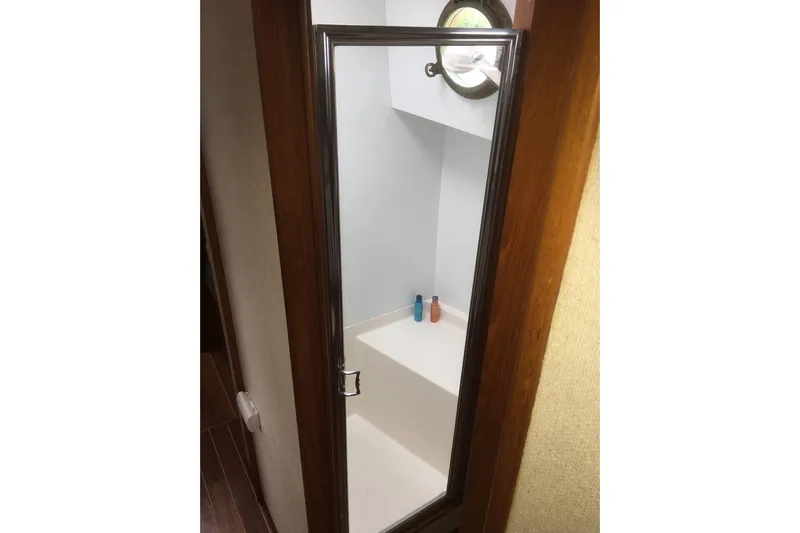  Yacht Photos Pics Mirror reflection in 1997 Willard Marine 40 Pilothouse Trawler bathroom with porthole and toiletries.
