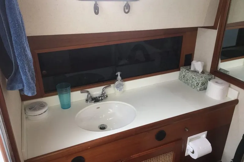  Yacht Photos Pics Bathroom sink area in a 1997 Willard Marine 40 Pilothouse Trawler, featuring wooden cabinetry.