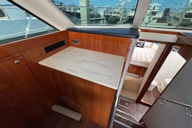  Yacht Photos Pics Interior of 2016 Riviera 43 Open Flybridge yacht with wood cabinetry and cozy bedroom.