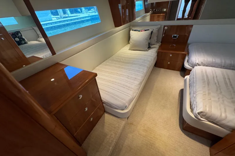  Yacht Photos Pics Luxurious 2016 Riviera 43 Open Flybridge cabin with twin beds and elegant wood furnishings.