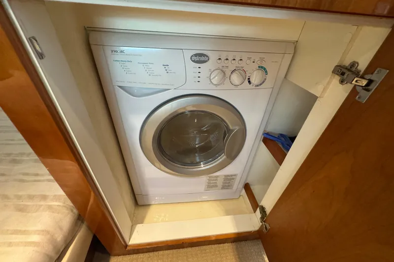  Yacht Photos Pics Washing machine inside 2016 Riviera 43 Open Flybridge yacht's wooden cabinet.