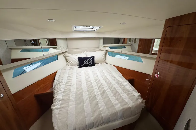  Yacht Photos Pics Luxurious bedroom interior of 2016 Riviera 43 Open Flybridge yacht with elegant wood finishes.