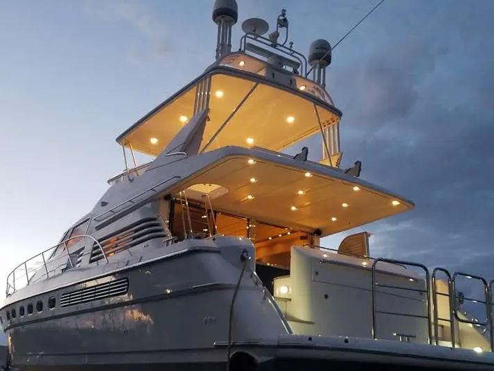 F66 Yacht Photos Pics 1997 Fairline 66 yacht illuminated at dusk, showcasing its elegant design and spacious decks.