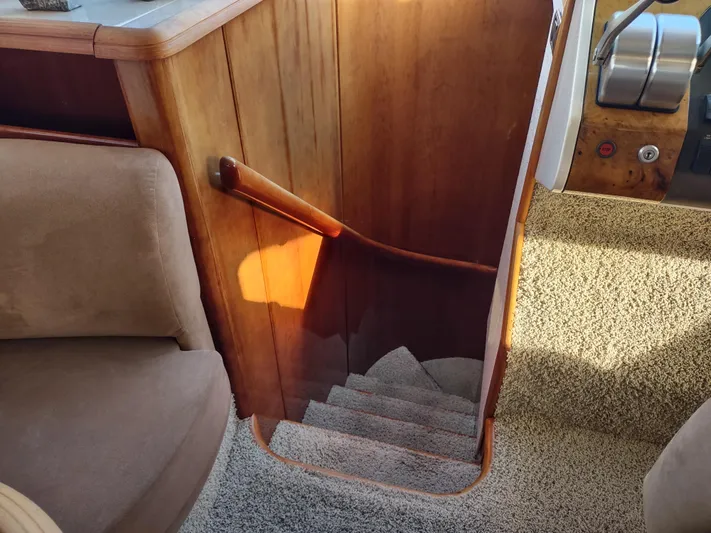 F66 Yacht Photos Pics Staircase inside a 1997 Fairline 66 yacht with wooden handrail and carpeted steps.
