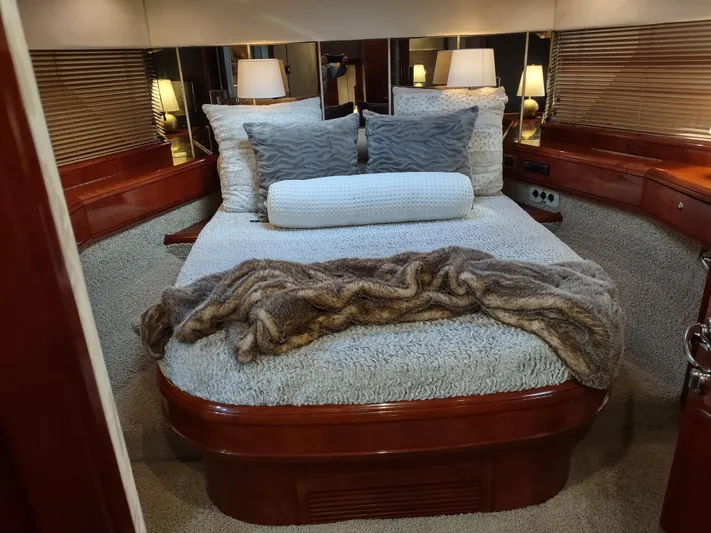 F66 Yacht Photos Pics Luxurious bedroom interior of a 1997 Fairline 66 yacht with cozy bedding and ambient lighting.