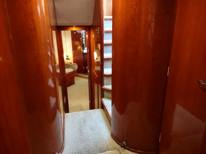 F66 Yacht Photos Pics Interior hallway of 1997 Fairline 66 yacht with wooden paneling and carpeted stairs.