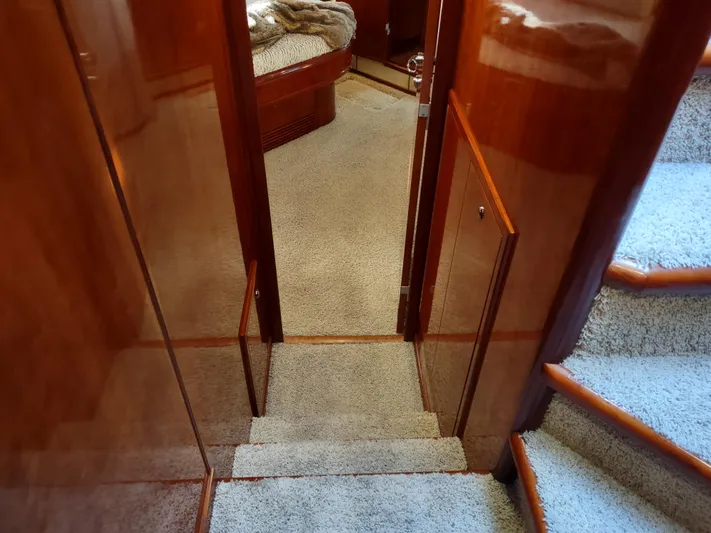 F66 Yacht Photos Pics Interior hallway of a 1997 Fairline 66 yacht with carpeted stairs and wooden paneling.