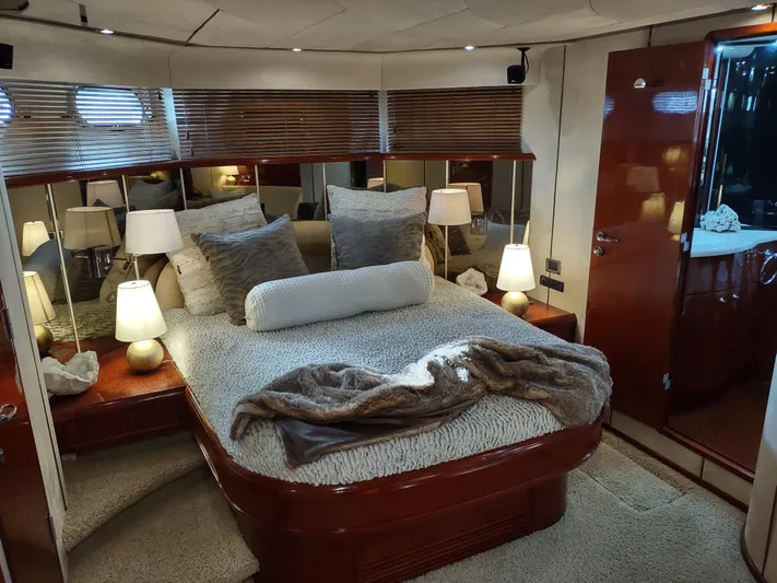 F66 Yacht Photos Pics Luxurious bedroom interior of a 1997 Fairline 66 yacht with cozy bedding and ambient lighting.