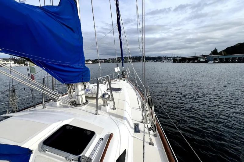  Yacht Photos Pics 1989 Taswell 43 sailboat with blue sail cover on calm waters.