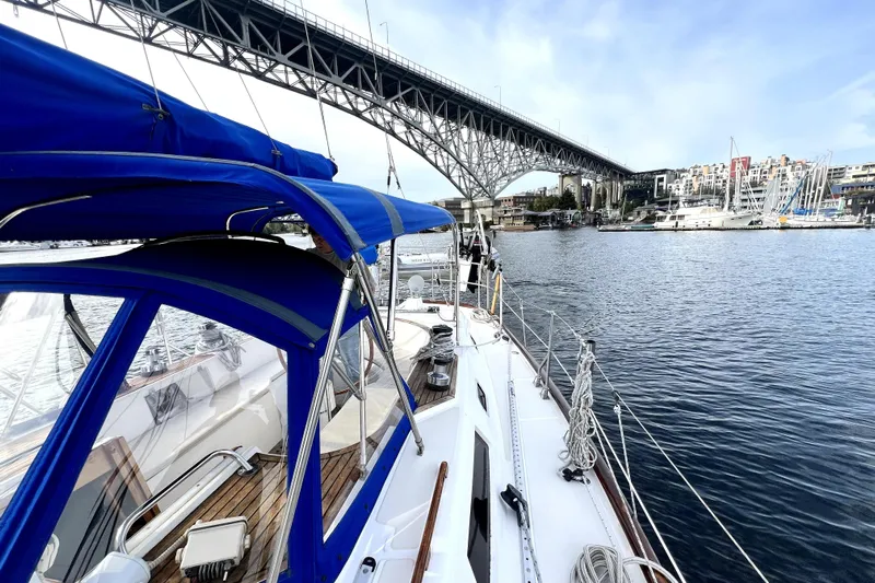  Yacht Photos Pics Sailboat Taswell 43 (1989) cruising under a bridge in a scenic marina setting.