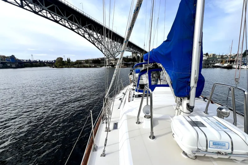  Yacht Photos Pics Sailboat Taswell 43 (1989) cruising under a bridge on a calm waterway.