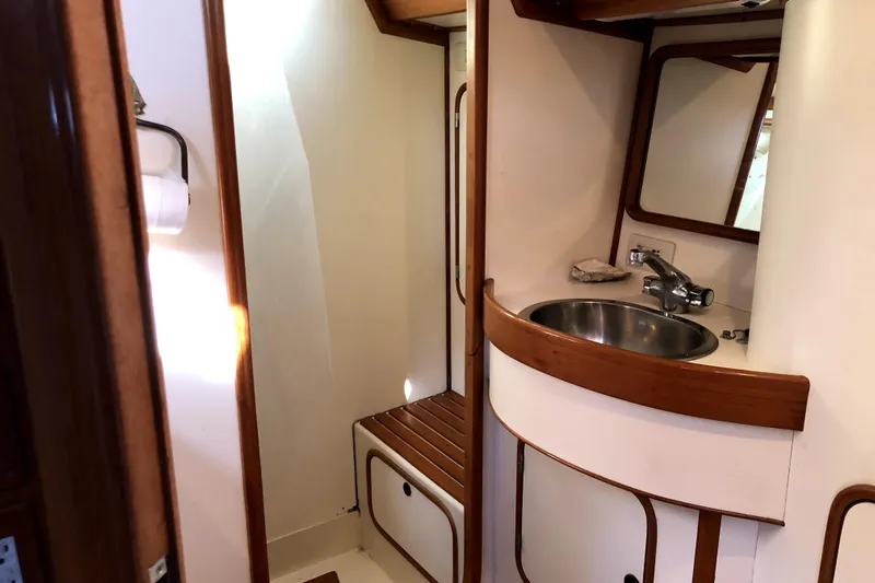  Yacht Photos Pics 1989 Taswell 43 yacht bathroom with sink, mirror, and wooden accents.