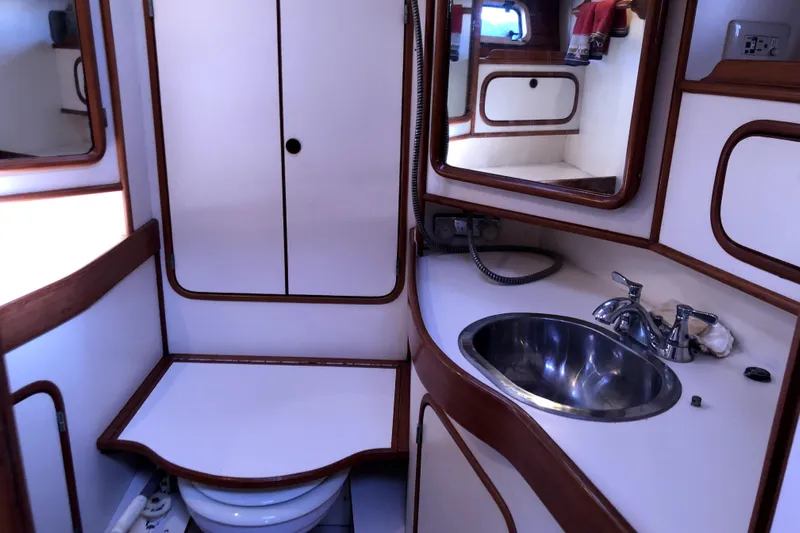  Yacht Photos Pics 1989 Taswell 43 yacht bathroom with sink, mirror, and storage cabinets.
